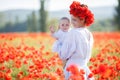 A happy mother with a small son in her arms on the endless field of red poppies on a sunny summer day Royalty Free Stock Photo