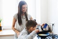 Happy mother with son cooking omelet in kitchen at home Royalty Free Stock Photo