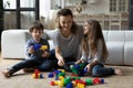 Happy mother with son and daughter playing on warm floor Royalty Free Stock Photo