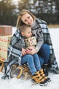 Happy mother and son having fun with sledge in a winter forest. Winter snowy day. Lovely boy with his mom on a sled Royalty Free Stock Photo