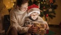 Happy mother with son looking inside magical Christmas present box. Families and children celebrating winter holidays. Royalty Free Stock Photo