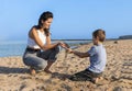 Happy Mother and son running and playing on beach barefoot, sunny day near the sea Royalty Free Stock Photo