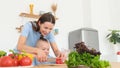 Happy mother and son prepare a healthy breakfast, they cut vegetables, prepare a vegetarian salad Royalty Free Stock Photo