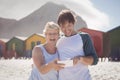 Happy mother with son using mobile phone at beach Royalty Free Stock Photo