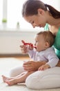 Happy mother with spoon feeding baby at home Royalty Free Stock Photo