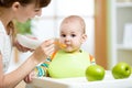 Happy mother spoon feeding her baby child Royalty Free Stock Photo