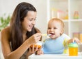 Happy mother spoon feeding her baby child Royalty Free Stock Photo