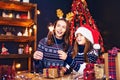 Holidays, family and people concept. Happy mother and little girl in santa helper hat with sparklers in hands, gift Royalty Free Stock Photo