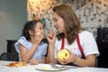 happy Mother teaching daughter peeling and eating  red apples together on table in kitchen at home . loving family.  child girl Royalty Free Stock Photo