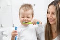 Happy mother teaching her son how to bush teeth Royalty Free Stock Photo