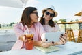 Happy mother and teen daughter talking and smiling. Parent with child in summer outdoor cafe enjoying a cold drink on a hot summer Royalty Free Stock Photo