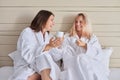 Happy mother and teenage daughter drinking coffee and talking Royalty Free Stock Photo