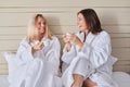 Happy mother and teenage daughter drinking coffee and talking Royalty Free Stock Photo