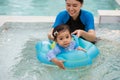 happy mother with toddler baby girl playing in an inflatable ring in swimming pool Royalty Free Stock Photo