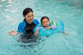 happy mother with toddler baby girl playing in an inflatable ring in swimming pool Royalty Free Stock Photo