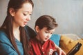 happy mother and toddler son using tablet at home. Family playing computer or searching internet Royalty Free Stock Photo