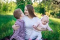 Happy mother with two children. Brother and sister with mummy in the Park. Mom hugging her son and holds baby Royalty Free Stock Photo