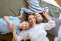 Happy mother with two children laying on bed at home having fun and playing Royalty Free Stock Photo