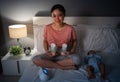 happy mother using breast pump machine to pumping milk with her newborn baby on bed at night Royalty Free Stock Photo