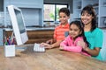 Happy mother using computer with her children Royalty Free Stock Photo