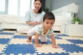 happy mother watching her infant baby crawlinf on play mat or jigsa floor in bedroom Royalty Free Stock Photo