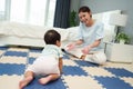 happy mother watching her infant baby crawlinf on play mat or jigsa floor in bedroom Royalty Free Stock Photo