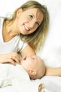 Happy mother on the white sofa with her baby Royalty Free Stock Photo