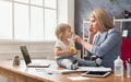 Young mother talking on phone and spending time with baby