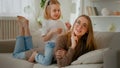 Happy motherhood family bonding affectionate love Caucasian mother lying on couch sofa daughter little girl child Royalty Free Stock Photo