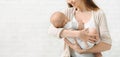 Young woman singing lullaby to her newborn baby and smiling