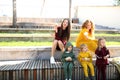 Happy mothers with children in the park in family-style clothes