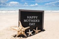 Happy Mothers day beach background with black board and starfishes Royalty Free Stock Photo