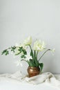 Happy Mothers day. Beautiful white tulips and daffodils in vintage vase on wooden table against rustic wall. Stylish simple spring Royalty Free Stock Photo