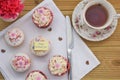 Happy mothers day cakes with iced pink flower decorations and cup of tea Royalty Free Stock Photo