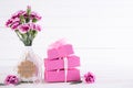 Happy mothers day concept. Gift box with pink carnation flower on white wooden table background