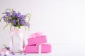 Happy mothers day concept. Gift box with purple flower on white wooden table background