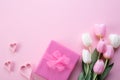 Happy mothers day concept. Top view of pink tulip flowers, gift box and paper heart on pink pastel background. Flat lay Royalty Free Stock Photo