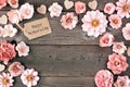 Happy Mothers Day frame with paper flowers and gift tag against a rustic wood background Royalty Free Stock Photo