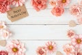 Happy Mothers Day frame with pink paper flowers and gift tag against a white wood background Royalty Free Stock Photo