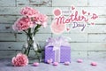 Happy mothers day message on wood background and pink carnation Royalty Free Stock Photo