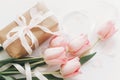 Happy Mothers day. Pink tulips flat lay with ribbon and gift box on white background. Stylish soft image of spring flowers. Happy Royalty Free Stock Photo