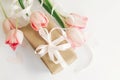 Happy Mothers day. Pink tulips flat lay with ribbon and gift box on white background. Stylish soft image of spring flowers. Happy Royalty Free Stock Photo