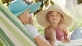 Happy mothers day, smiling mom playing with her blue eyed little girl daughter child, plays with her by putting on a big straw hat Royalty Free Stock Photo