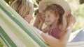 Happy mothers day, smiling mom playing with her blue eyed little girl daughter child, plays with her by putting on a big straw hat Royalty Free Stock Photo