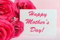 Happy Mothers Day text on gift card in flower bouquet of pink roses on pink background. Greeting card for Mom. Flower delivery, Royalty Free Stock Photo