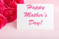 Happy Mothers Day text on gift card in flower bouquet of pink roses on pink background. Greeting card for Mom. Flower delivery, Royalty Free Stock Photo