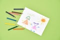 Happy mothers day. Top view of a child drawing and colored pencils on a green background Royalty Free Stock Photo