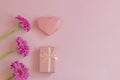 Happy Mothers Day, Womens Day, Valentines Day or Birthday. Gerbera, gift and heart on a pink background. Floral flat lay with Royalty Free Stock Photo