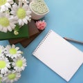 Bouquets of soap flowers, blank notepad with pencil, books on light blue background. Royalty Free Stock Photo