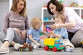 Group of happy moms with their babies in nursery Royalty Free Stock Photo